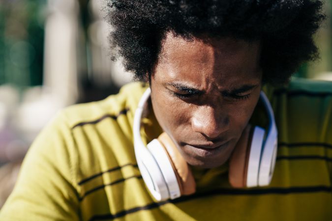 Tense male looking down while wearing headphones