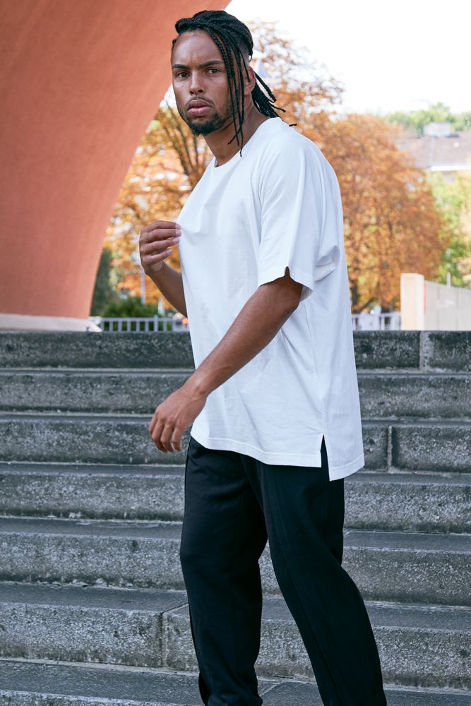 Trendy Black man posing near modern arch