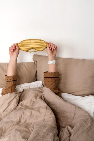 Hands up with sleep mask and smartwatch