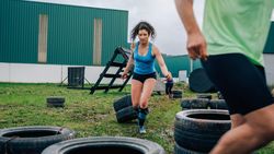 Participant in an obstacle course dragging wheels