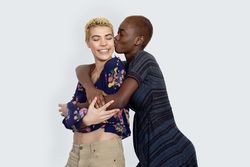 Smiling female couple embracing in studio