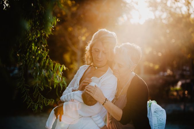 Two mature women feeding a baby with a bottle