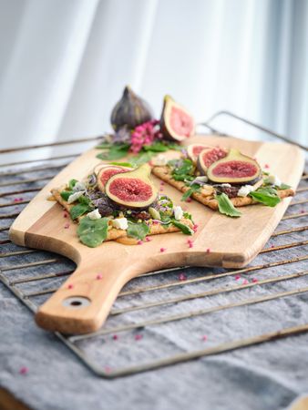 Delicious toast with slices of fig on cutting board