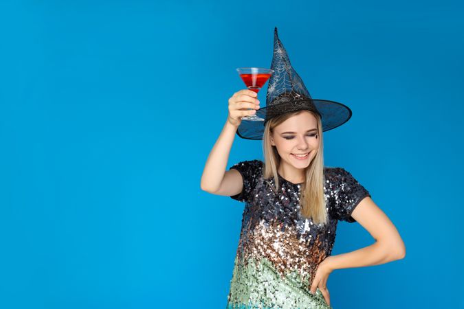 Concept of Halloween, young woman on blue background