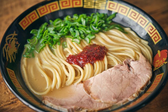 Delicious ramen with pork slices and cooked noodles in bowl
