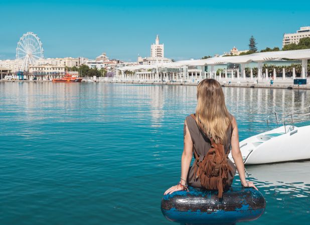 faceless woman looking on water and city