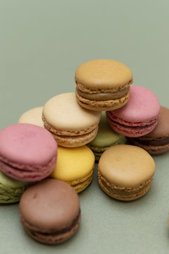 Pile of tasty French macaroons on a green counter