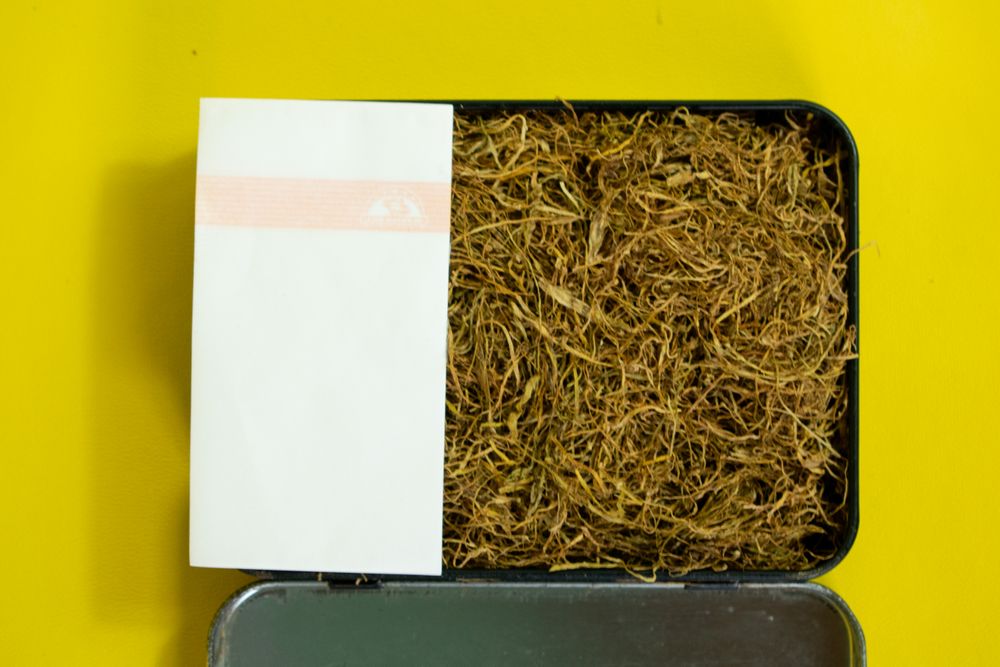 Top view of box of loose leaf tobacco with rolling papers