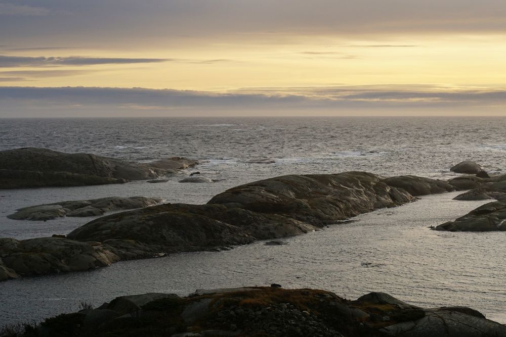 Rocky seashore and dark wavy sea in dusk