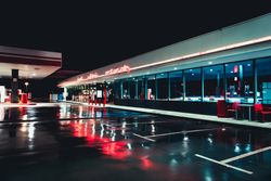 Empty retro gas station with cafe at night after rain