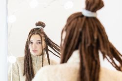Woman with braids looking in the mirror