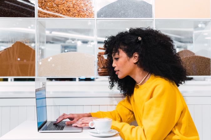 Black woman working on laptop in cafe