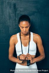 Sporty woman with eyes closed looking down with a jump rope around neck bYXVY4