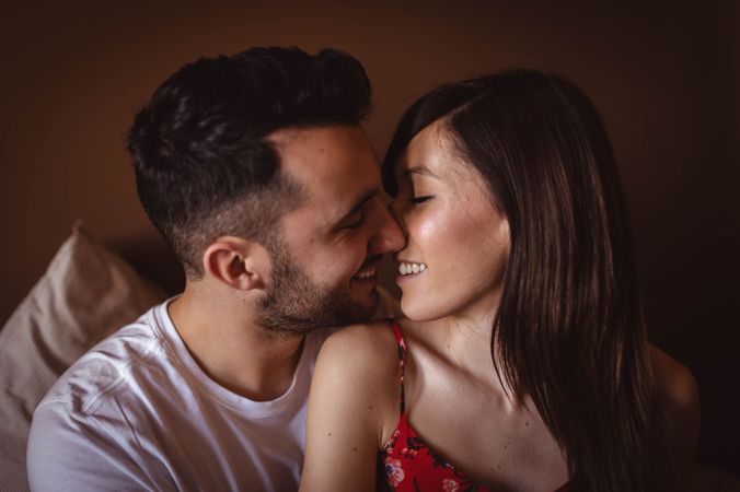 Happy couple sitting on bed