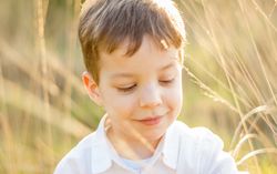 Kid in field playing with spikes at summer sunset