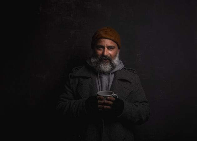 Portrait of smiling middle aged man with gray hoodie with cup of hot tea