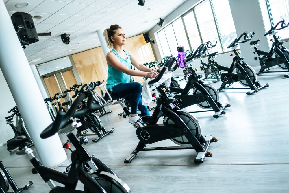 Woman with towel and water on exercise machine
