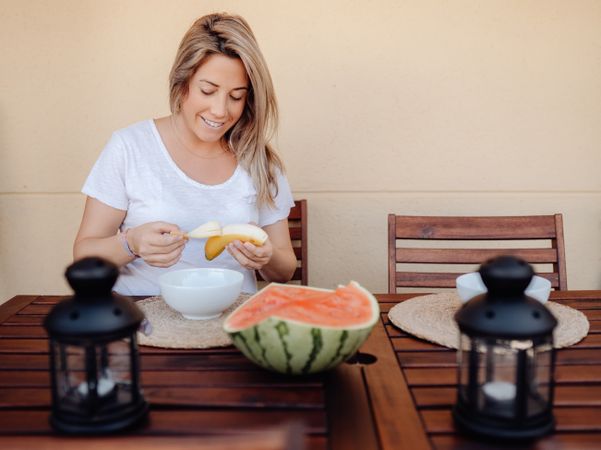 Pregnant woman peeling banana to bowl