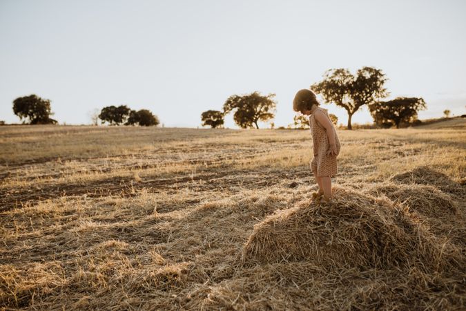 Little girl standing on a pile of hay