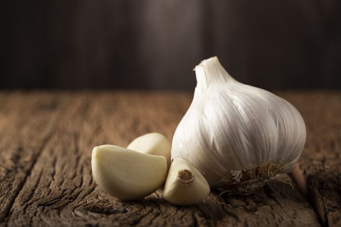 Garlic bulb and garlic cloves on the wooden table.