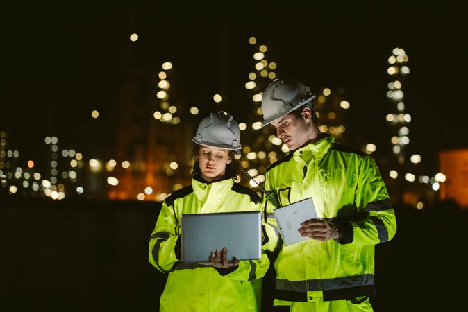 Engineer worker watching work monitor on tablet and checking at refinery factory