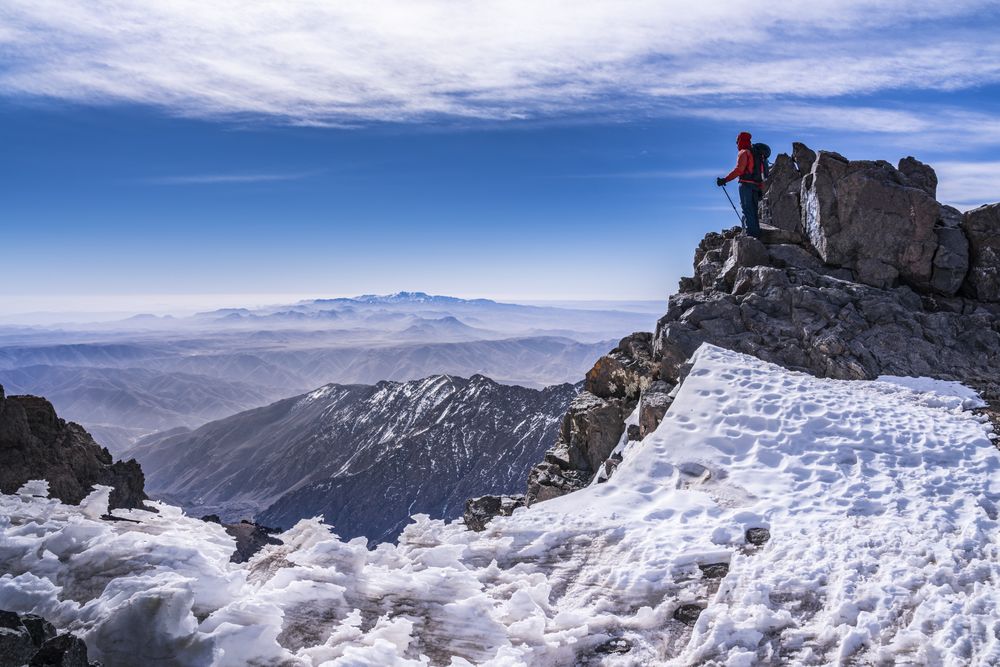 Tourist enjoying breathtaking view at snowy mountain top