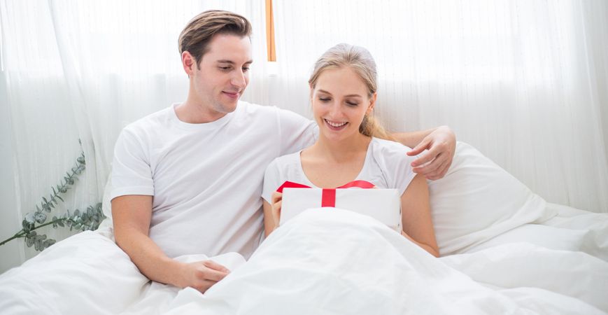 Man giving a gift box to his girlfriend for surprise on Valentine's