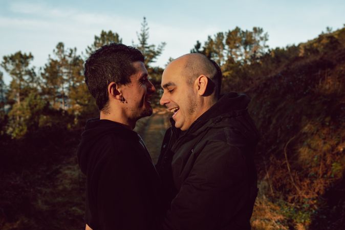 Smiling men hugging on countryside road