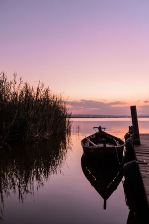 Moored boat by wooden pier