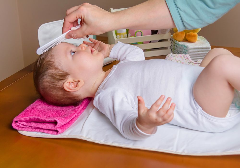 Mother grooming hair of baby