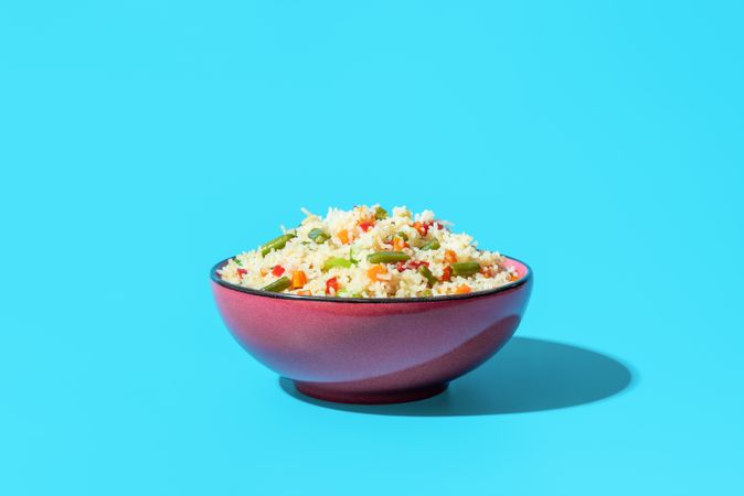 Fried rice with vegetables, an asian dish, on a blue background