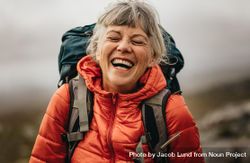 Portrait of a woman hiker laughing during her hiking trip bYwyX5