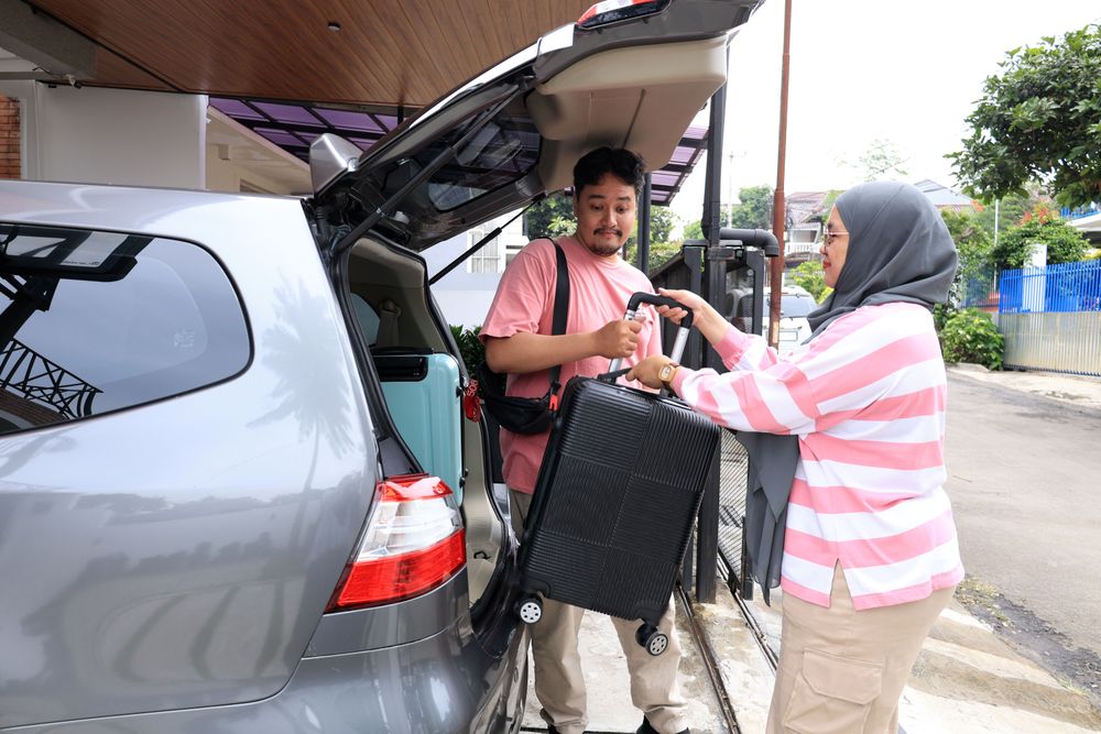 Indonesian Muslim Couple Loading Luggage to The Car Trunk
