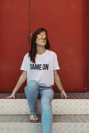 Young woman sitting on steps near door