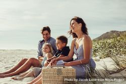 Family with kids sitting on the beach bGnG24