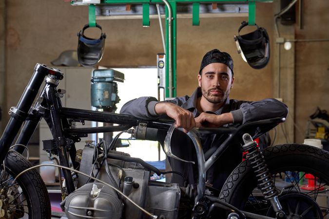 Serious mechanic repairing motorbike in garage