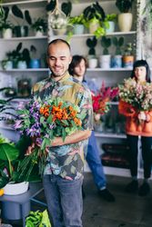 Man holding colorful flowers in the flower shop.