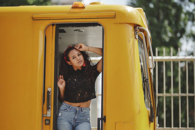 Cheerful hispanic woman standing on train in drivers cabin