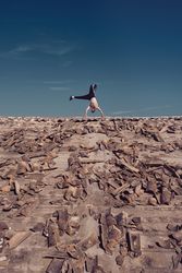 Man dancing breakdance on roof on building