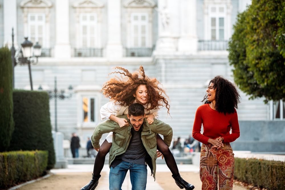 Three young friends playing piggy back