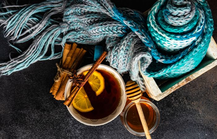 Tea time concept with blue knitted scarf and tea served with lemon