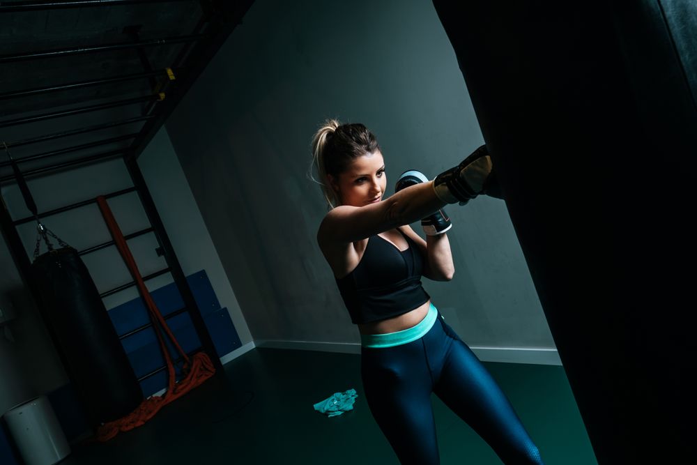 Woman training in gym with punching bag