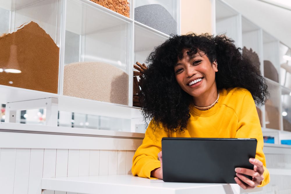 Black female using tablet against wall