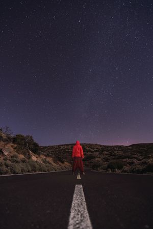 Traveler standing on empty road at night