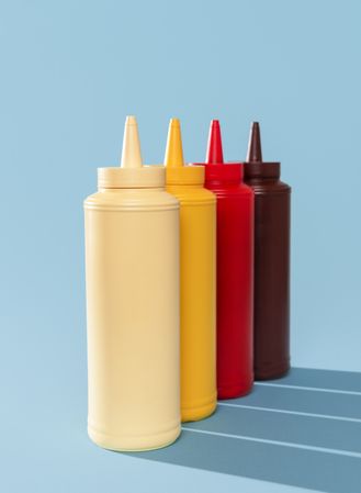 Sauce bottles aligned on a blue table