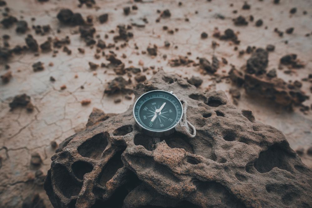 Big compass on dry cracked desert area