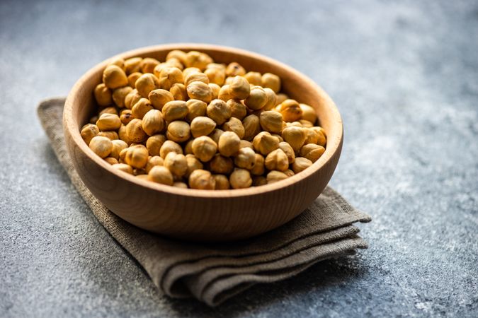 Shelled hazelnuts in bowl on grey counter