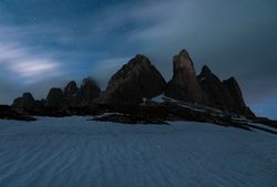 Dark mountains on white plain under starry sky
