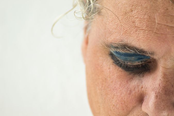 Close-up shot of sad middle aged man's eye with eyeshadow