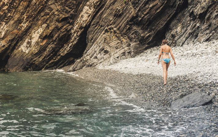 Woman walking near cliff and sea